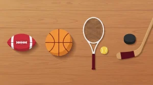 Fußball, Basketball, Tennisschläger und weitere Sportgeräte auf einem Holztisch